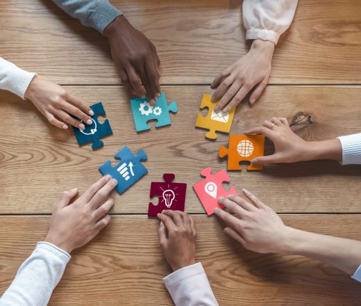 Hands assembling puzzle pieces representing association services