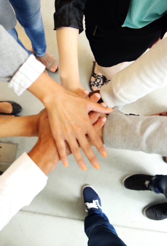 Team members joining hands together
